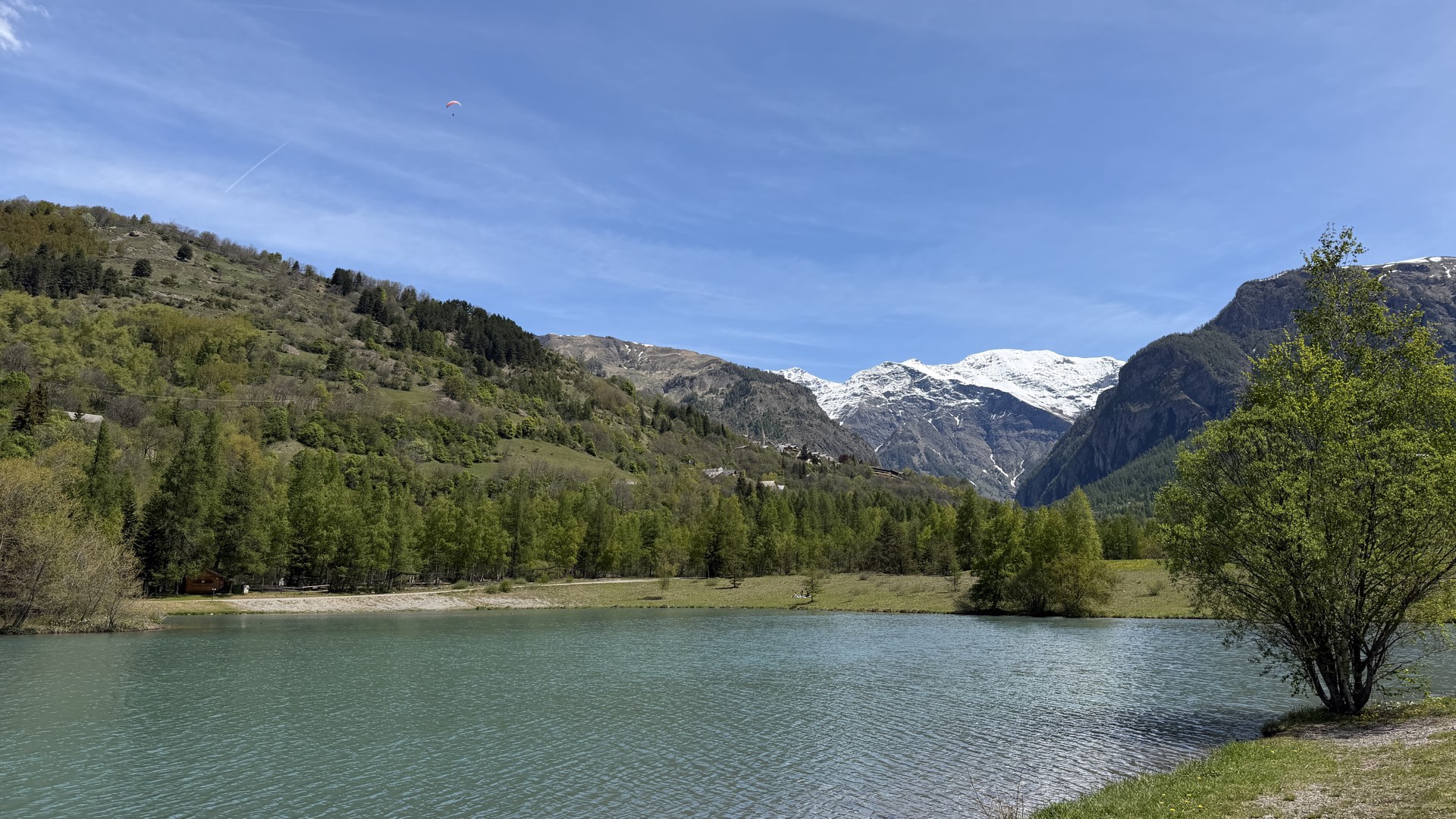 Lac turquoise avec parapente en vol au-dessus des Écrins, Orcières Merlette