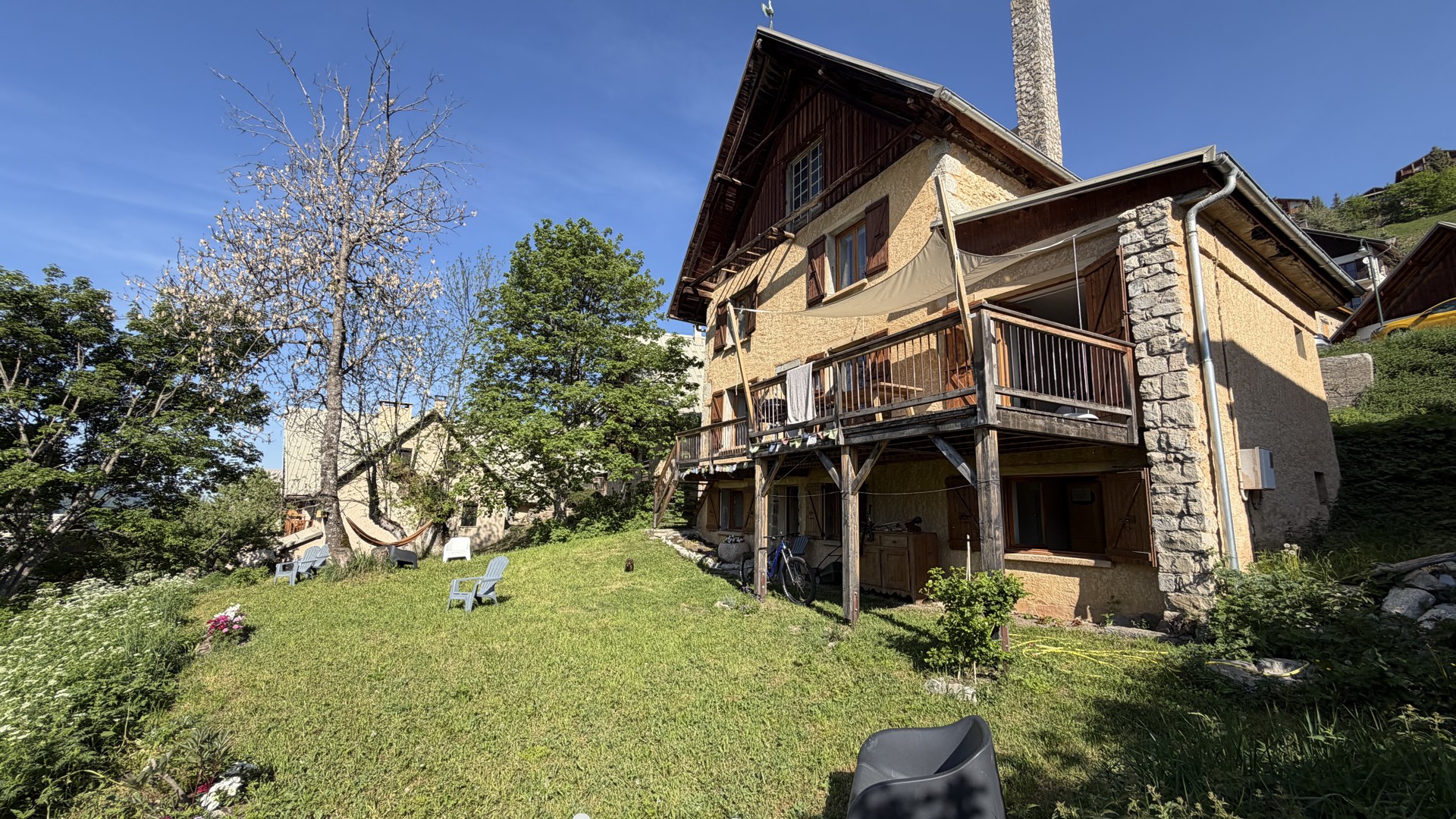 Façade du chalet des Écrins en pierre et bois traditionnels, architecture montagnarde