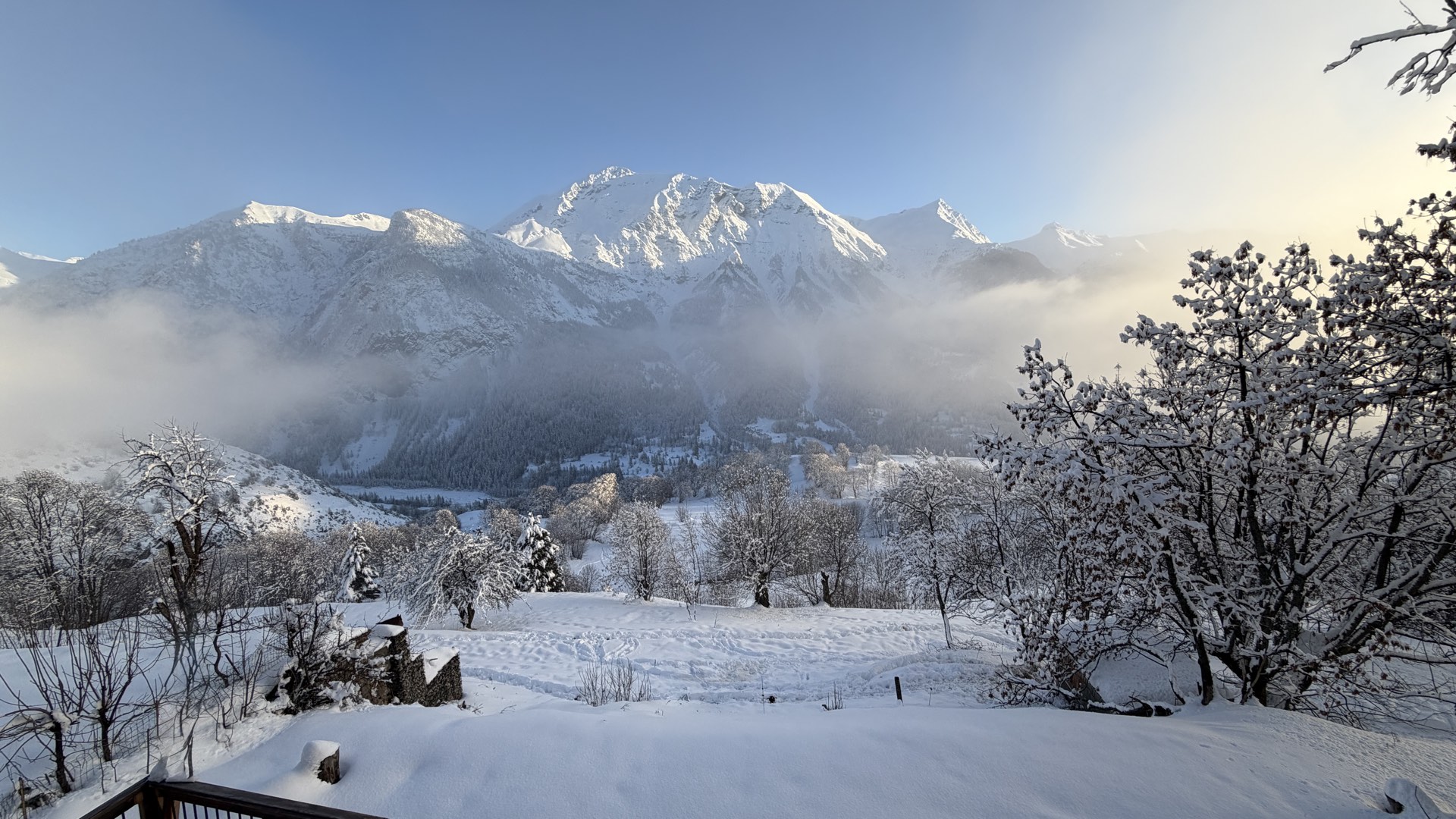 Village des Estaris sous la brume hivernale, lumières dorées dans la nuit neigeuse, Orcières Merlette